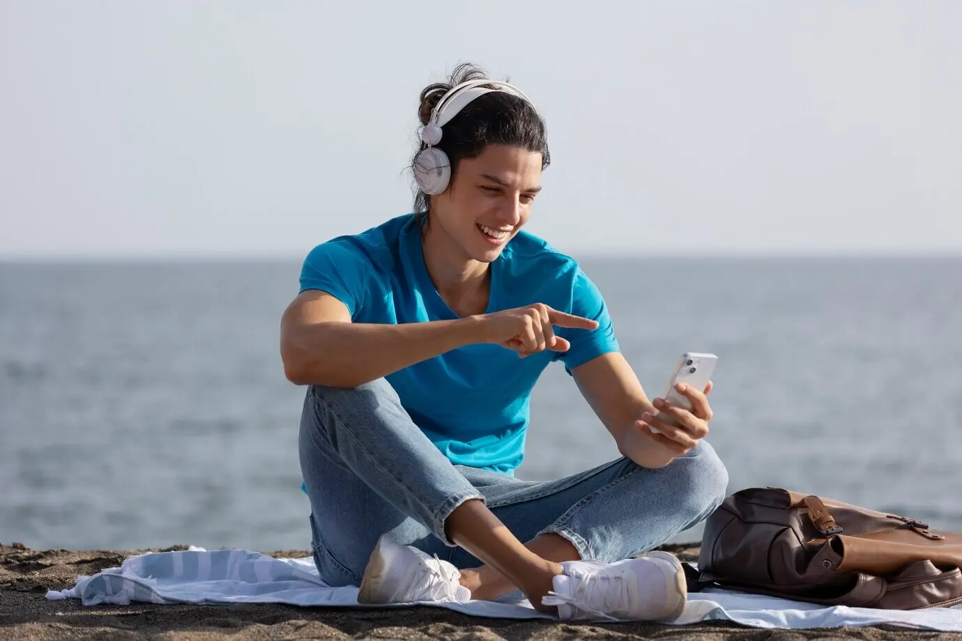 Ganzkörperaufnahme eines Mannes, der ein Smartphone hält.